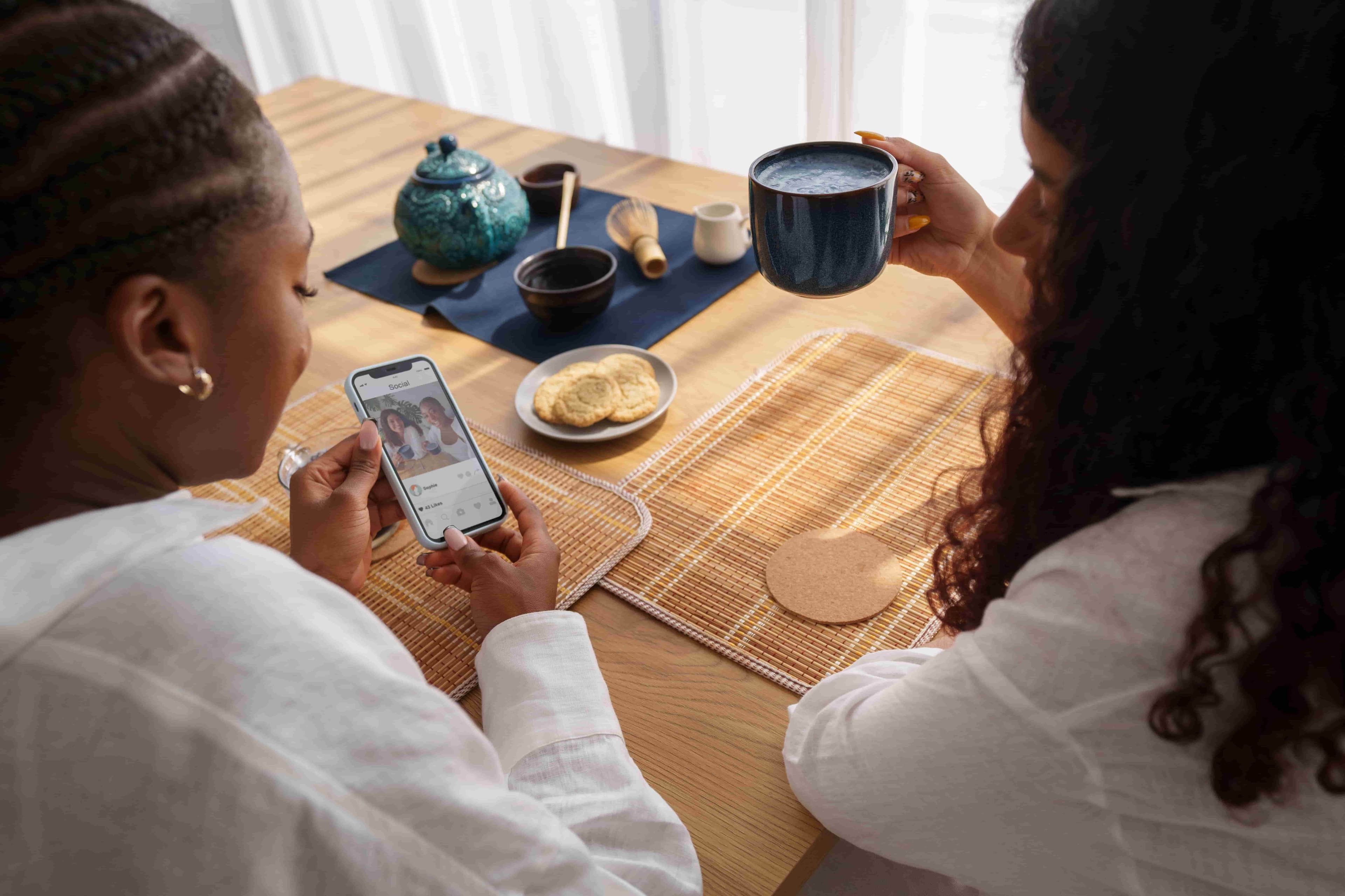 Two friends planning a trip together on a phone